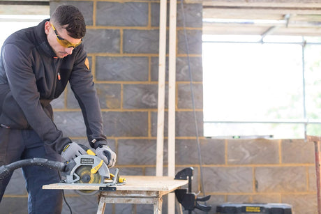 Scie circulaire grise Stanley FATMAX, outil électroportatif, couleur grise et jaune, utilisée sur chantier.
