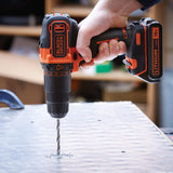 Perceuse sans fil Black+Decker, outil électroportatif noir et orange en action