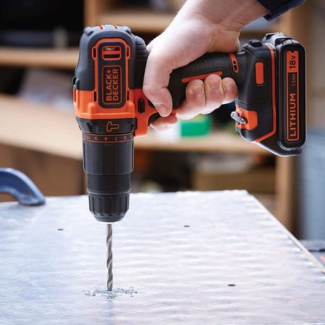 Perceuse sans fil Black+Decker, outil électroportatif noir et orange en action