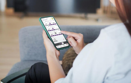Thermostat connecté Sauter, type contrôle intelligent, couleur vert, en utilisation sur smartphone.