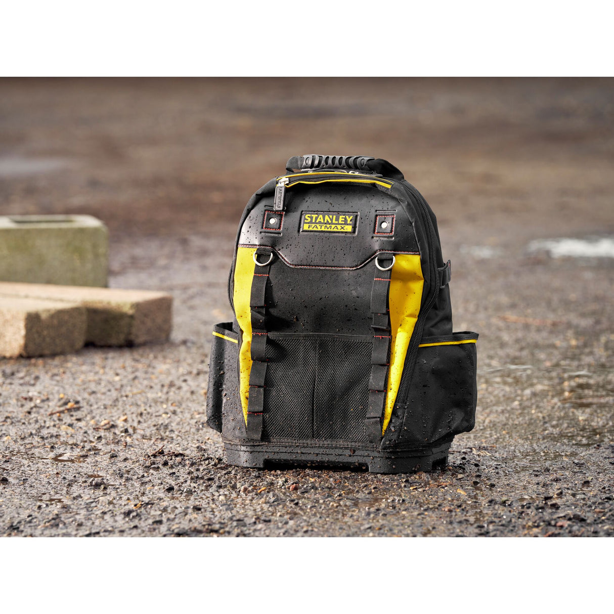 Sac à outils Stanley Fatmax, sac à dos noir et jaune, robuste, posé sur sol mouillé