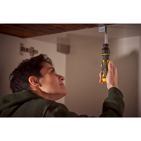 Tournevis Stanley noir et jaune utilisé pour bricoler sous un meuble