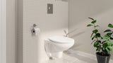 WC suspendu TOTO blanc, design moderne, installé sur mur carrelé avec plante décorative