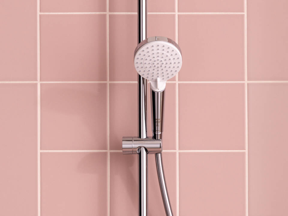 Douchette Hansgrohe, type pommeau de douche, finition chromée sur carrelage rose.