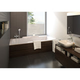 Baignoire Grohe rectangulaire blanche, tablier bois foncé, robinetterie moderne, salle de bain élégante