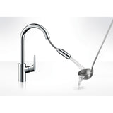 Mitigeur cuisine Grohe chromé avec douchette extractible, eau versée dans une louche.