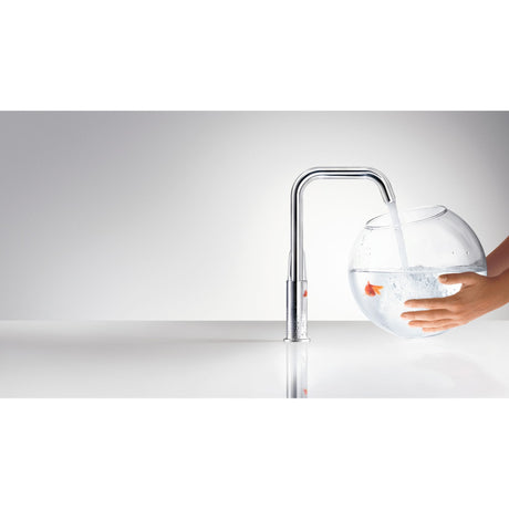 Mitigeur Grohe, robinet de cuisine chromé, moderne, remplissant un aquarium transparent.