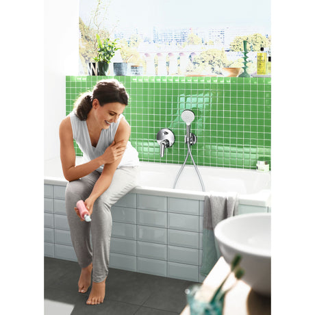 Mitigeur de baignoire Grohe, chromé, installé sur carrelage vert dans salle de bain