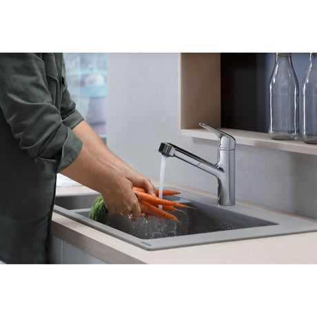 Mitigeur de cuisine Grohe chromé, robinet moderne, finition brillante, utilisé pour laver des carottes