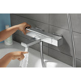 Mitigeur de bain chromé Hansgrohe, robinet mural, eau coulant dans une baignoire blanche