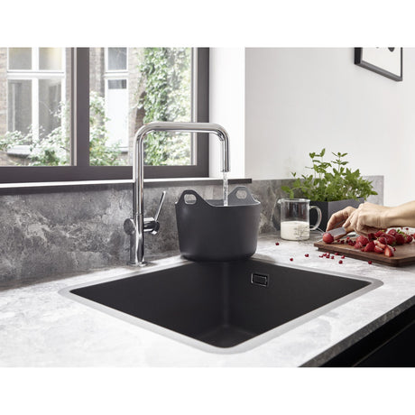 Mitigeur cuisine Grohe, robinet noir et chrome, design moderne, au-dessus d’un évier noir.