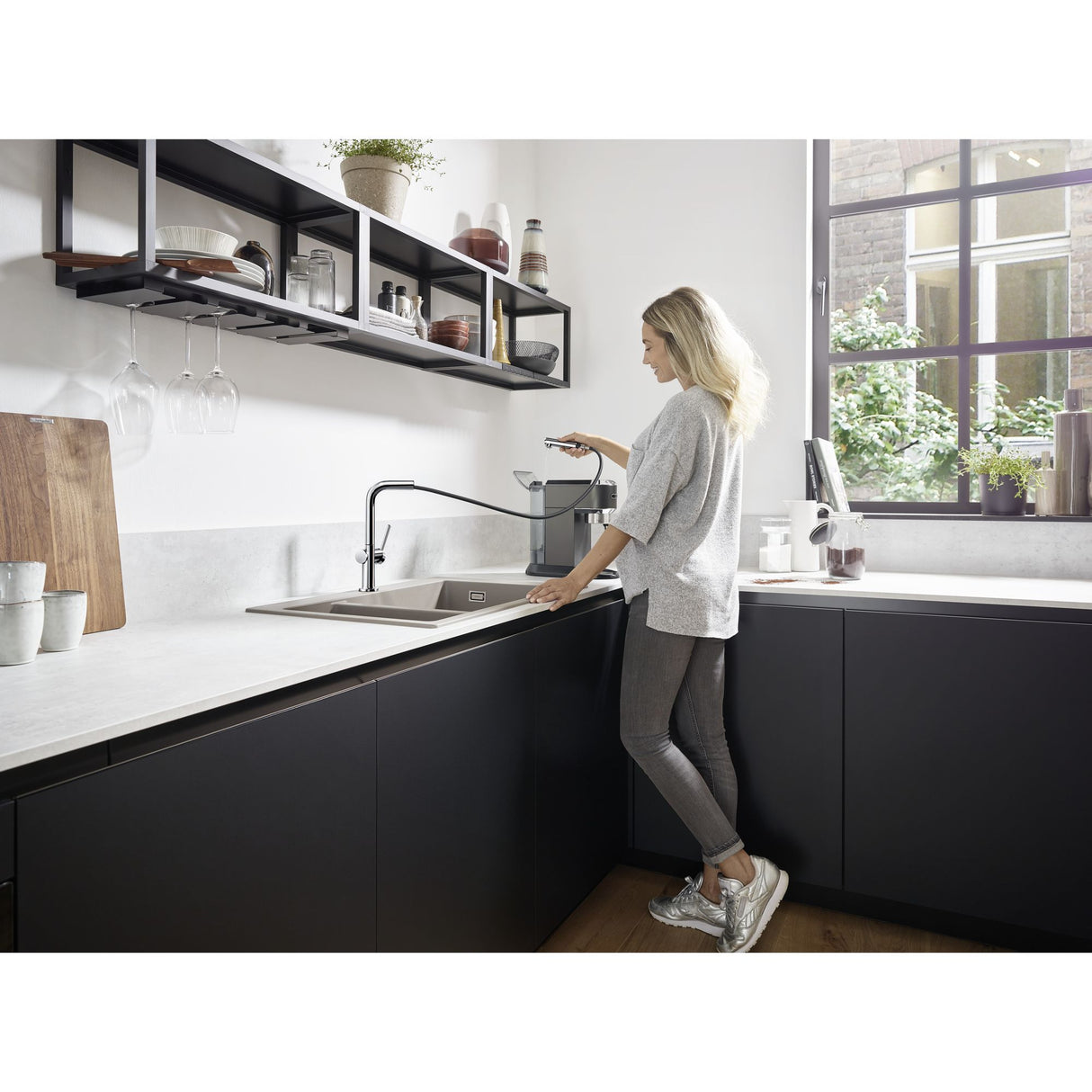 Mitigeur cuisine Grohe noir avec jet extractible, robinet design moderne, femme utilisant l'évier