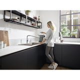 Mitigeur cuisine Grohe noir avec jet extractible, robinet design moderne, femme utilisant l'évier