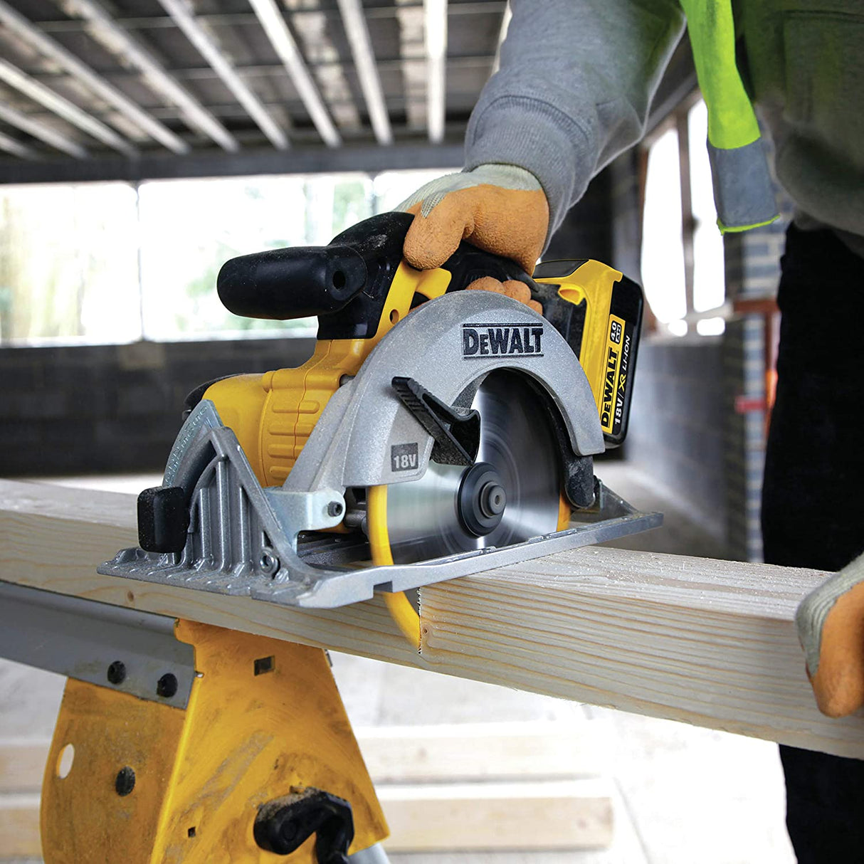 Scie circulaire portative Dewalt, couleur jaune et gris, en action sur une planche de bois.