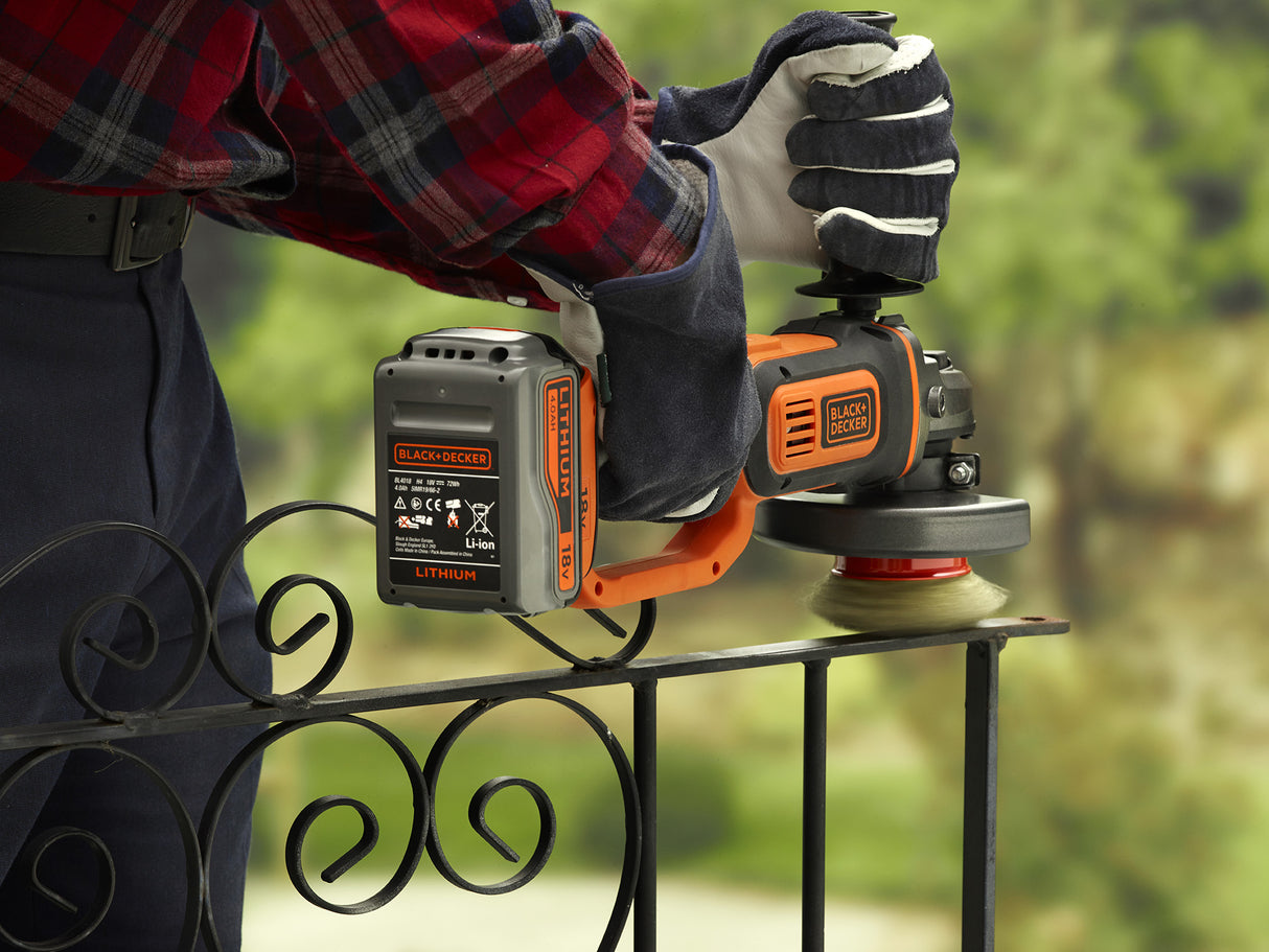 Meuleuse sans fil Black+Decker orange et noire en action sur une rambarde en métal