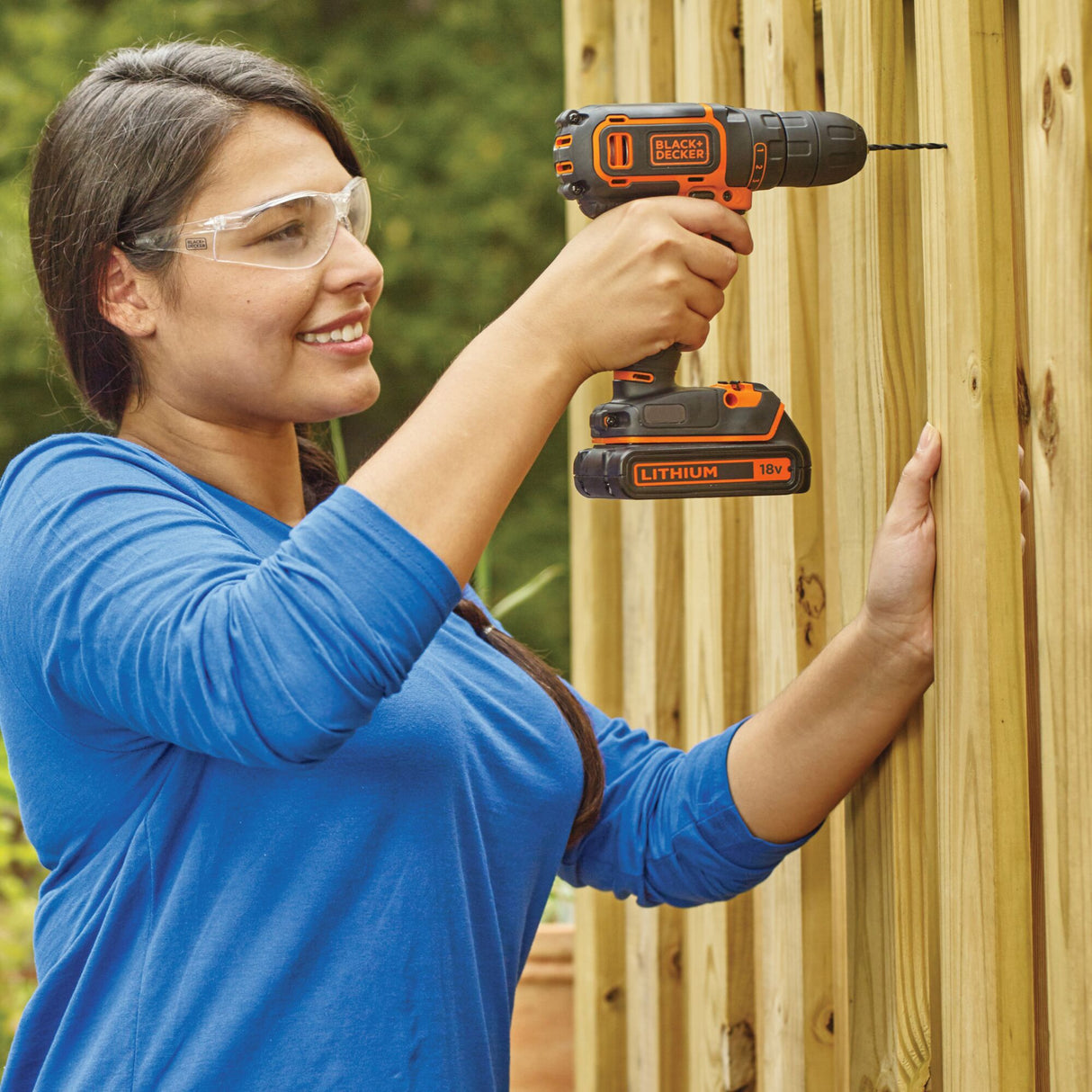 Perceuse-visseuse sans fil BLACK+DECKER, outil électroportatif noir et orange en action