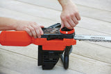 Tronçonneuse Black+Decker orange et noire en cours d’ajustement