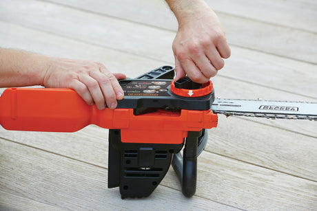 Tronçonneuse Black+Decker orange et noire en cours d’ajustement