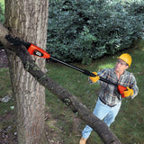 Élagueuse télescopique Black+Decker orange et noire utilisée pour couper une branche d’arbre.