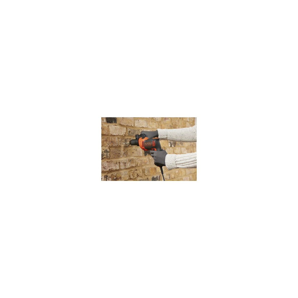 Perceuse Black+Decker, outil électroportatif, couleur orange et noire, utilisée sur un mur en brique
