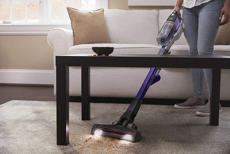 Aspirateur balai BLACK+DECKER sans fil, violet, nettoyant tapis sous table basse.