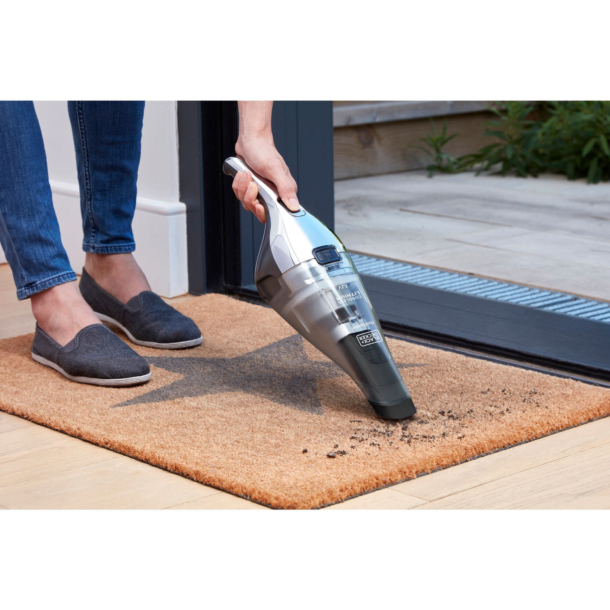 Aspirateur à main Black+Decker, électrique, couleur gris argent, utilisé sur un paillasson