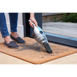 Aspirateur à main Black+Decker, électrique, couleur gris argent, utilisé sur un paillasson