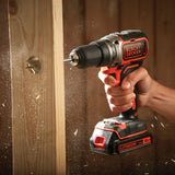 Perceuse visseuse Black+Decker sans fil, couleur noire et orange, en action sur bois