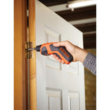 Visseuse électrique Black+Decker, outillage, couleur orange et noire, utilisée sur une charnière de porte