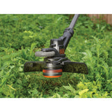 Débroussailleuse Black+Decker noire en action, coupe-herbe sur gazon vert