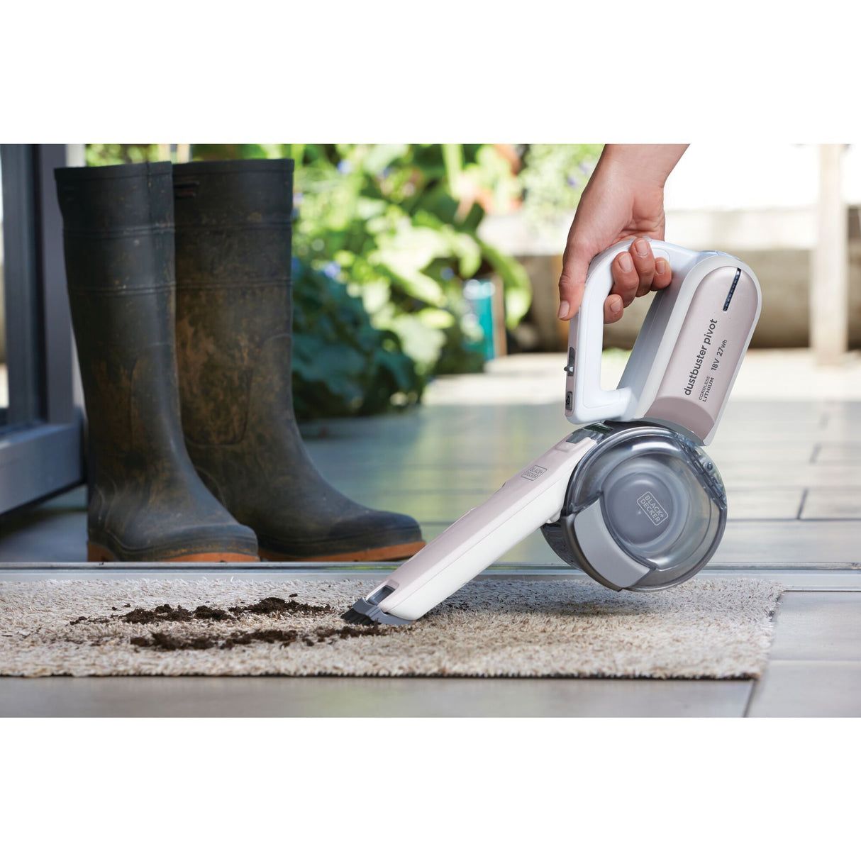 Aspirateur à main Black+Decker blanc nettoyant une moquette sale