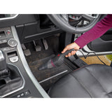 Aspirateur à main Black+Decker, type nettoyeur de voiture, couleur noir, en usage sur tapis de voiture.