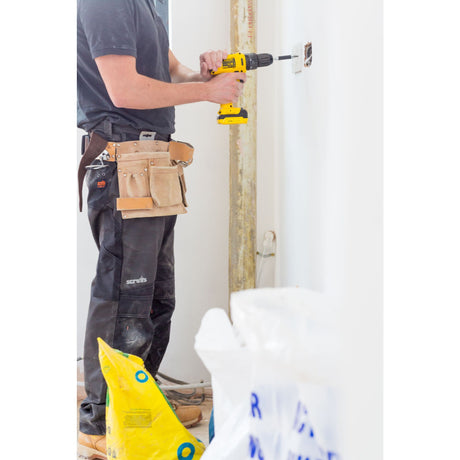 Perceuse sans fil DeWalt, outil électroportatif jaune, utilisée par un artisan