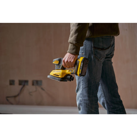 Ponceuse sans fil jaune Stanley Fatmax, outil électroportatif de couleur noire et jaune, tenue à la main.