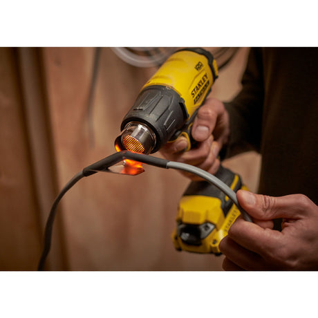 Décapeur thermique jaune Stanley, outil électrique couleur jaune en utilisation
