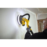 Ponceuse murale jaune Stanley utilisée sur un mur, outil électrique de couleur jaune.