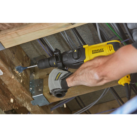 Perforateur électrique jaune Stanley FATMAX utilisé pour percer du bois, outil électroportatif.