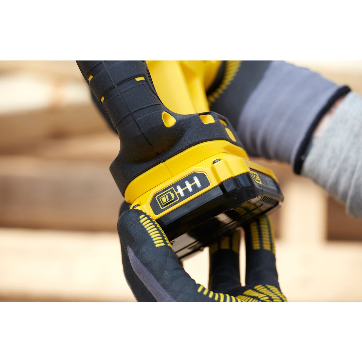 Perceuse visseuse DeWalt de couleur jaune et noire, prise en main avec gants de protection.