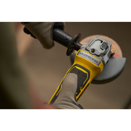 Meuleuse électrique DeWalt, jaune et noire, outil brushless en utilisation.