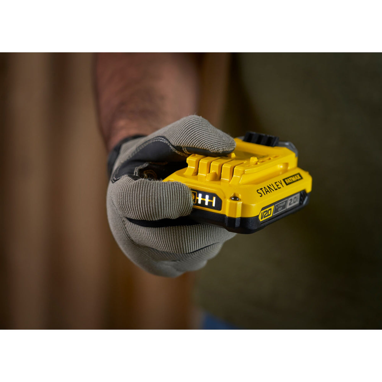 Batterie Stanley V20 jaune pour outillage électroportatif, tenue en main, couleur jaune.