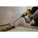 Marteau perforateur Stanley, outillage électrique jaune et gris, utilisé sur un mur