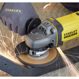 Meuleuse d’angle Stanley Fatmax jaune utilisée pour découper du métal, étincelles visibles.