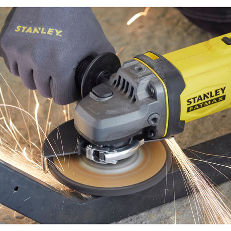 Meuleuse d’angle Stanley Fatmax jaune utilisée pour découper du métal, étincelles visibles.