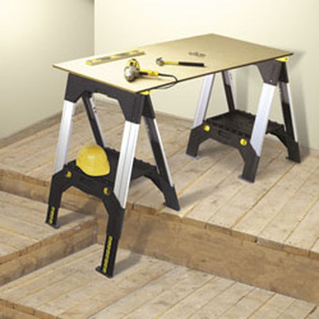 Établi Stanley, établi multifonction noir et jaune avec plateau, sur plancher en bois.