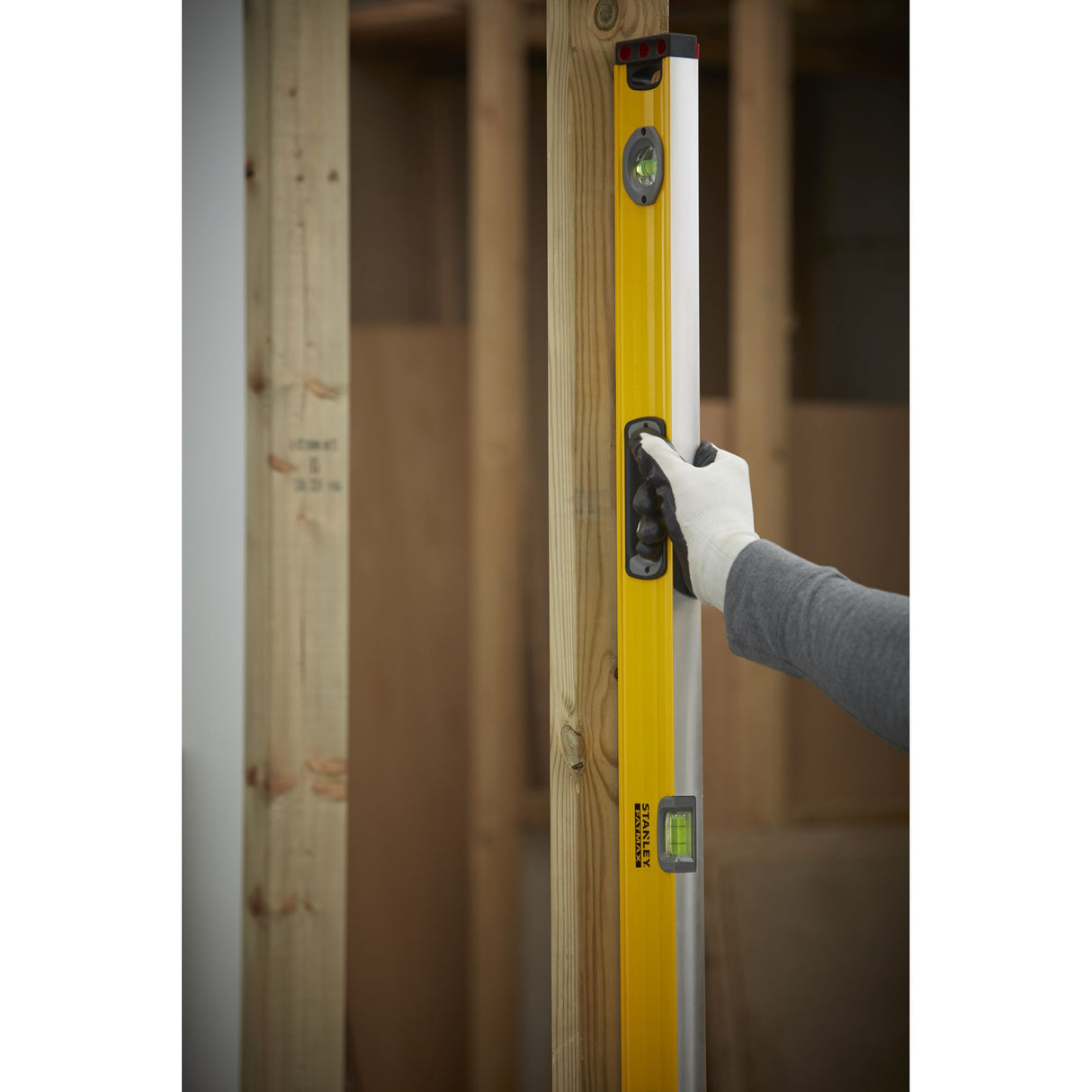 Niveau à bulle Stanley, outil de mesure jaune utilisé sur un chantier.