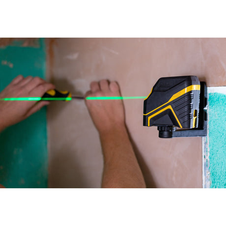 Niveau laser Stanley, outil de mesure noir et jaune avec faisceau vert, fixé au mur.