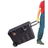 Boîte à outils Facom noire à roulettes, transportée par une personne
