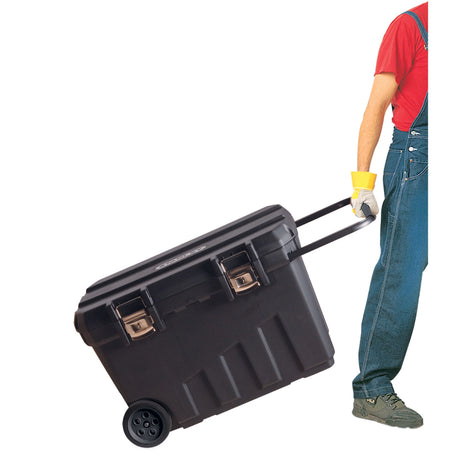 Boîte à outils Facom noire à roulettes, transportée par une personne