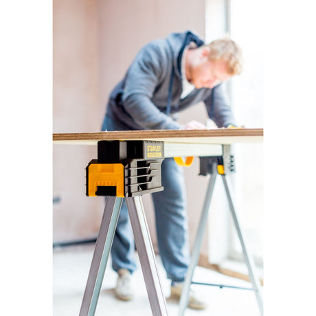 Tréteau pliant Stanley Fatmax noir et jaune, utilisé pour travaux de bricolage.