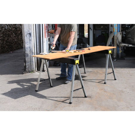 Tréteaux Stanley, table de travail pliable, couleur noire et jaune, utilisés en extérieur.